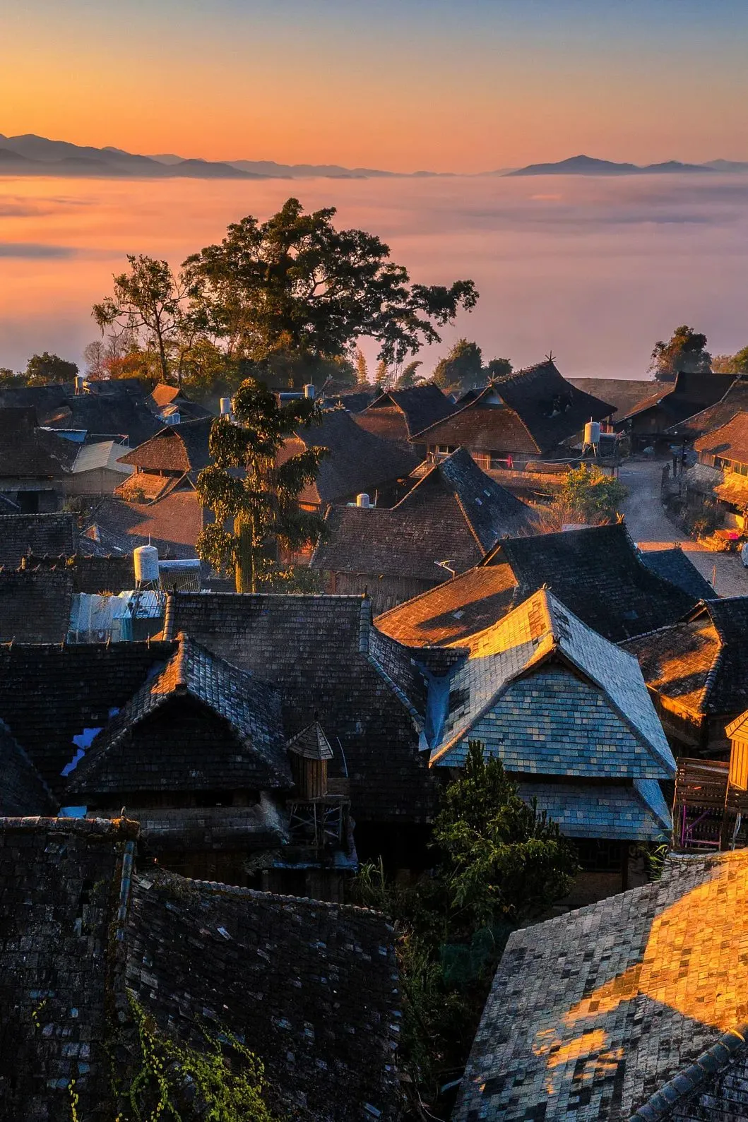 远处的云海与静谧的村寨，构成一幅层次分明的图景 图/视觉中国